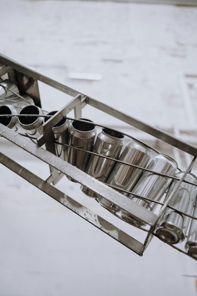 pexels-photo-5532658-5532658 Close-up of metallic cans on a conveyor belt in an automated manufacturing facility.